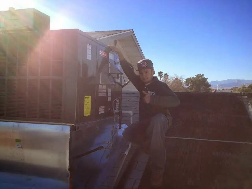 HVAC technician performing AC Tune-Up on a rooftop unit in Darlington